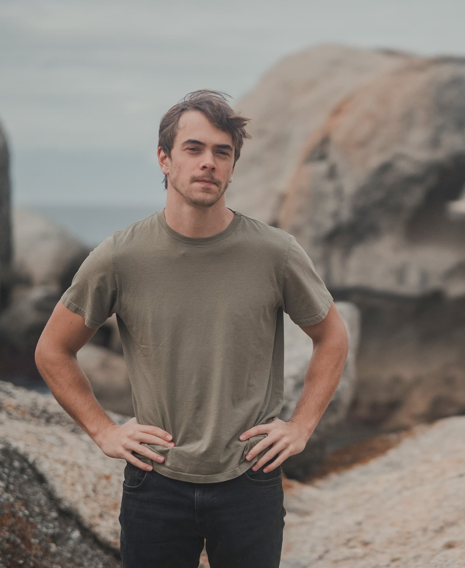 Matt Derman standing between coastal rocks